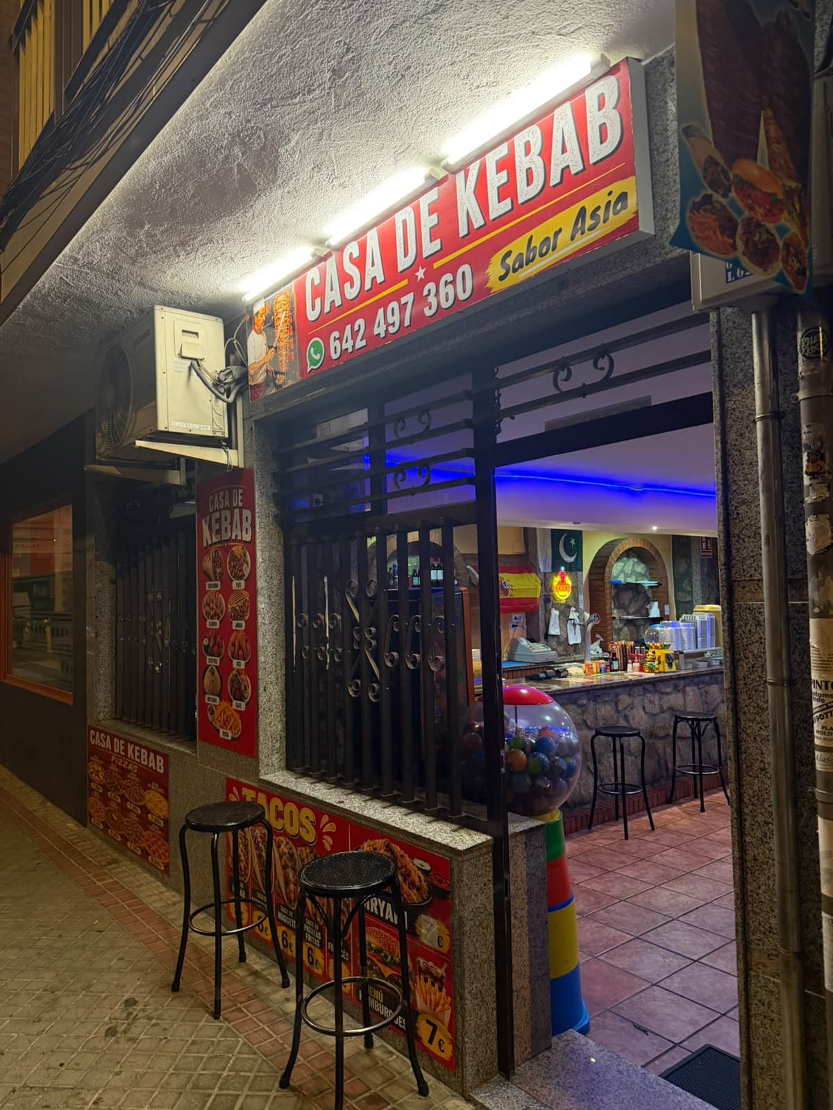Rótulo rojo de Casa de Kebab Sabor Asia visto desde la acera