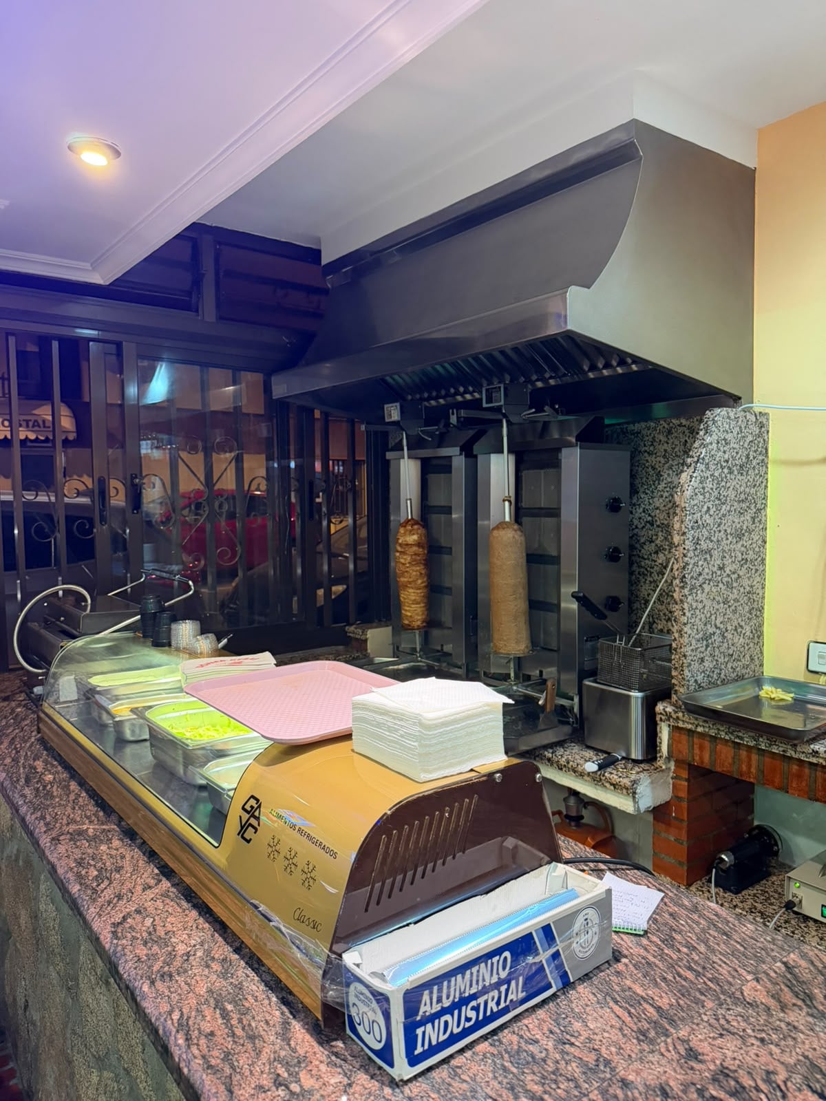 Dos conos de döner girando en el asador detrás de la barra
